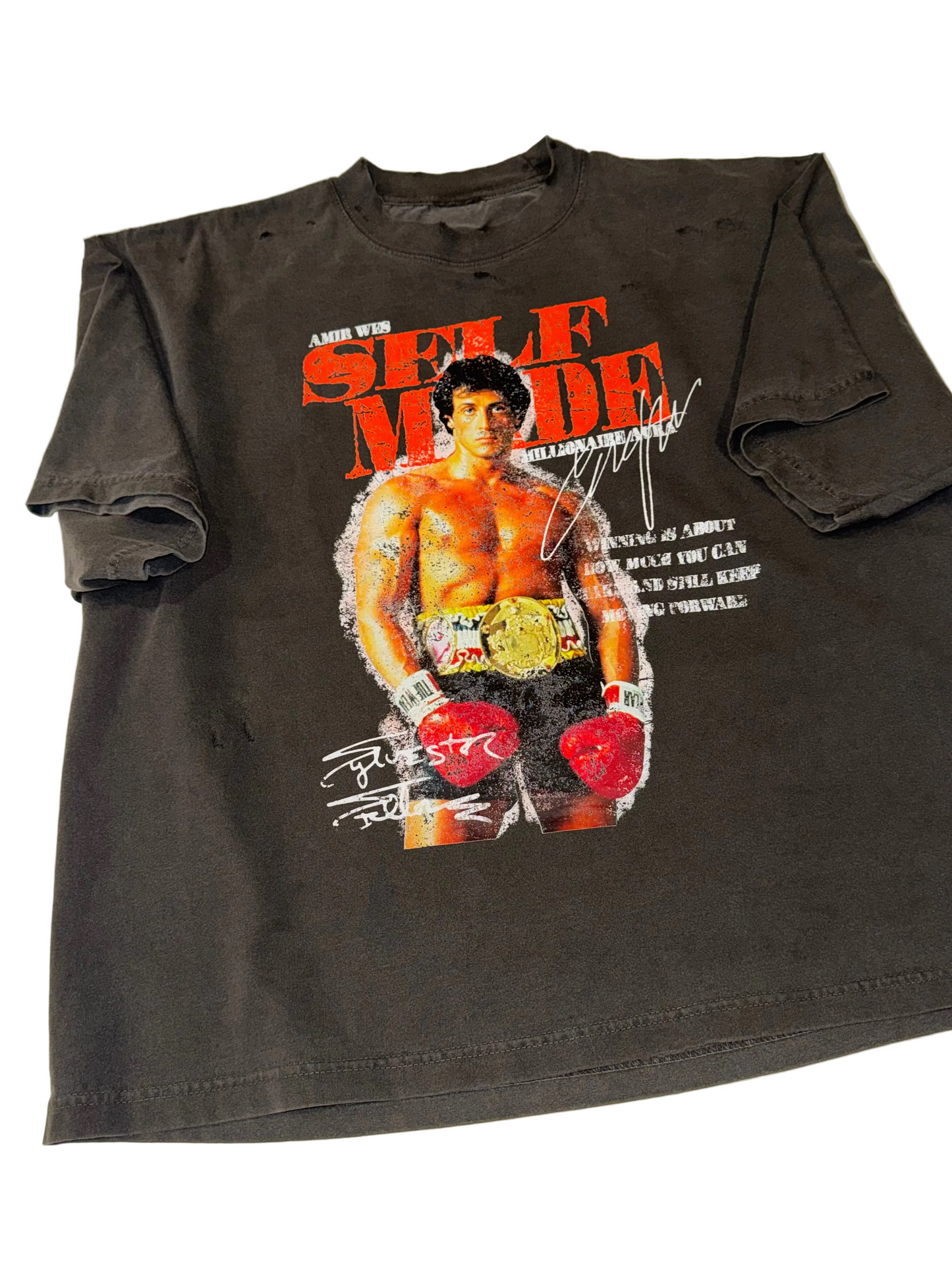 A dark gray graphic t-shirt featuring a printed image of Rocky Balboa from 'Rocky' with the text 'Self Made' and boxing gloves, laid flat on a white surface.